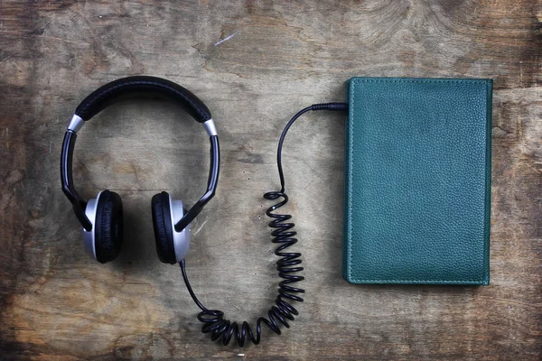 Audiolibro cuffie e libro su tavolo in legno — Foto Stock