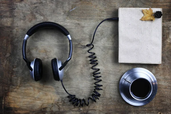 Auriculares audiolibros y libro sobre mesa de madera — Foto de Stock