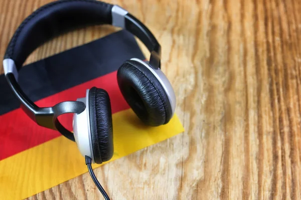 Curso língua fone de ouvido e bandeira em uma mesa — Fotografia de Stock