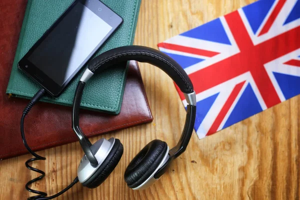 Auriculares y bandera sobre fondo de madera —  Fotos de Stock