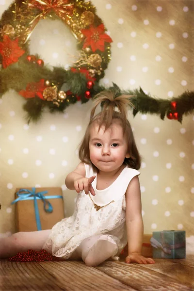 Vintage effekt på foto lilla flicka klänningar upp julgran på — Stockfoto