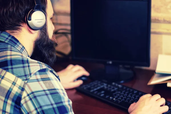 Mann hinter Computer mit Kopfhörer — Stockfoto
