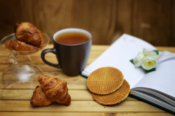 Xícara com livro de croissant chá — Fotografia de Stock