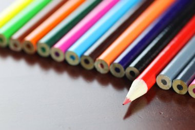 ahşap masa üzerinde renkli kalemler