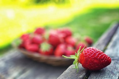 Hasır plaka ahşap arka plan üzerinde çilek