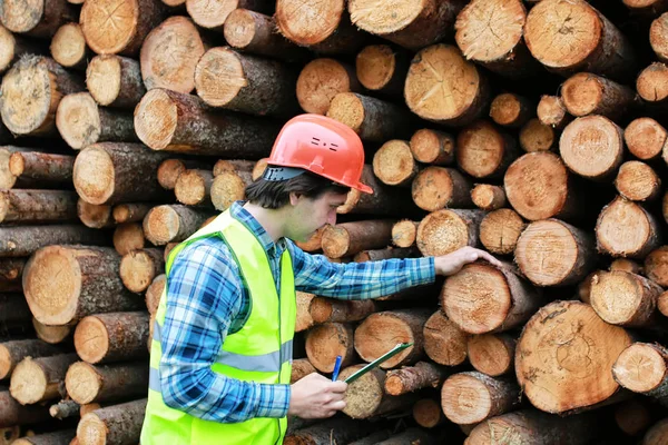 Homme dans casque travailleur bois de sciage — Photo