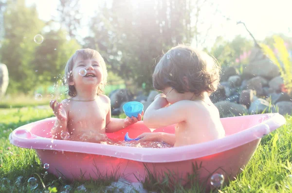 お風呂の水を屋外で子供たち — ストック写真