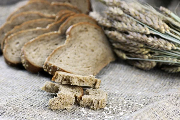 Ржаной хлеб и уши на столе — стоковое фото