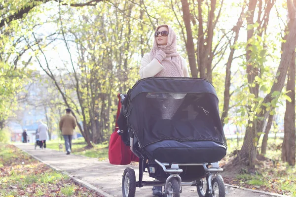 Girl in the park with stroller — Stock Photo, Image