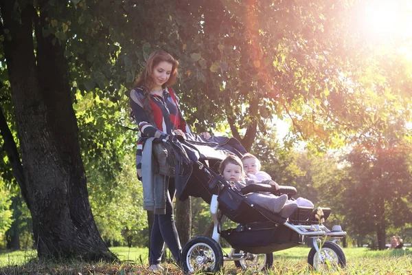 Caminar mujeres con cochecito luz del sol de verano —  Fotos de Stock