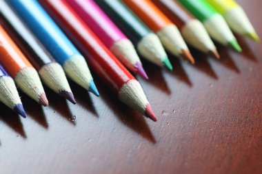 ahşap masa üzerinde renkli kalemler