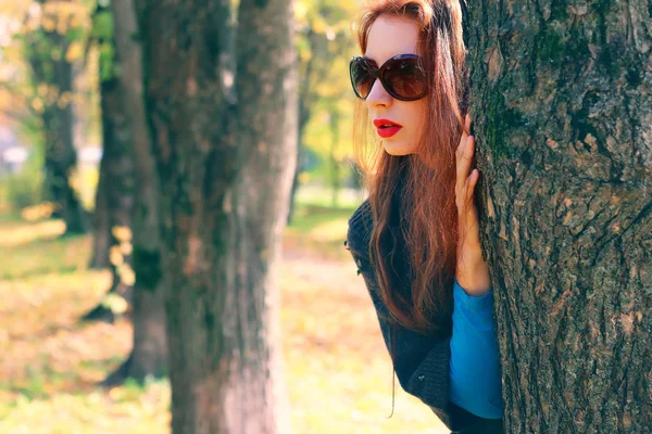 Девушка осенью листья пальто солнцезащитные очки — стоковое фото