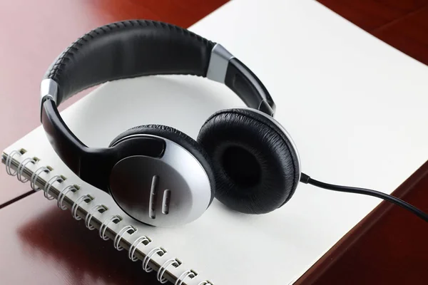 Headphones on a table next to the tablet and a clock — Stock Photo, Image