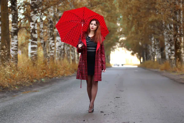 Frau in Regenmantel und Regenschirm — Stockfoto