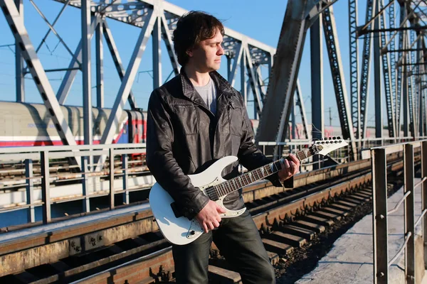 Homem com uma guitarra em uma estrada de ferro — Fotografia de Stock