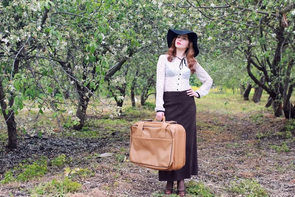 Mujer en vestido retro al aire libre maleta parque — Foto de Stock