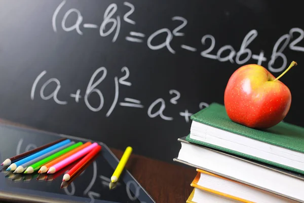 Manzana roja en el cuaderno con pila de libros —  Fotos de Stock