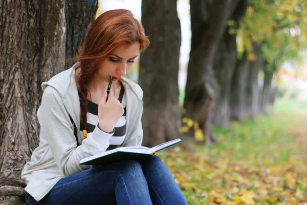 Herbst verlässt Mädchenbuch beiläufig — Stockfoto