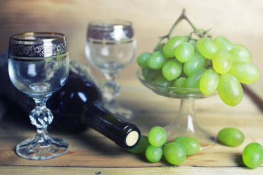 üzüm ve şarap şişesi kitap ile ahşap masa