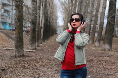 Sonbaharda parkta kulaklıklı bir kadın.