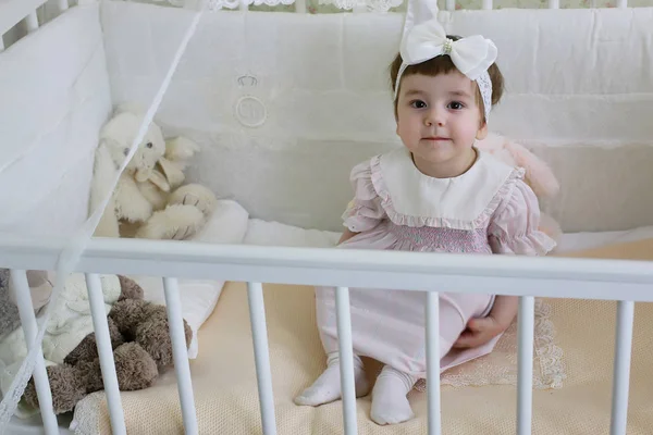 Kleines Kind sitzt im Kinderbett — Stockfoto