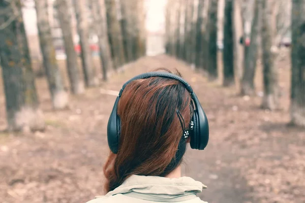 Flicka i parken med hörlurar — Stockfoto