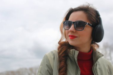 Sonbaharda parkta kulaklıklı bir kadın.