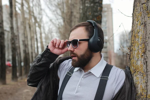 Man met baard en koptelefoon in het park — Stockfoto