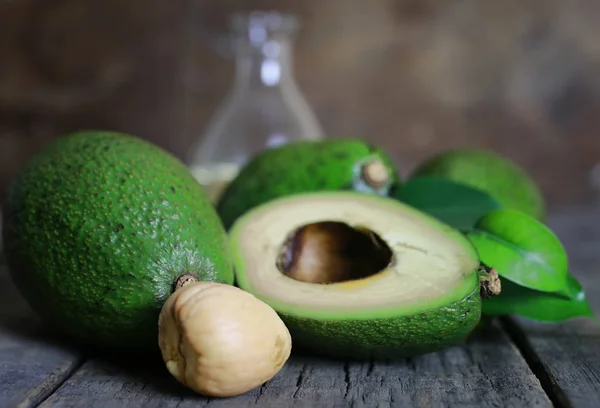 Avocado and oil on wooden background — Stock Photo, Image