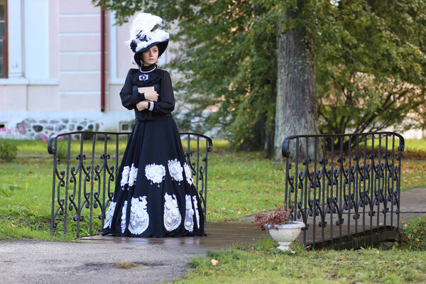 renaissance woman with book on the bridge in the park