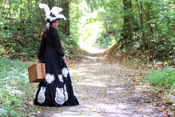 Meisje in de 18e eeuw retro jurk met valise in park — Stockfoto