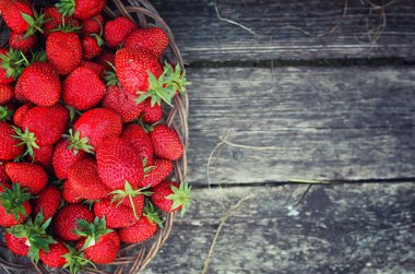 Hasır plaka ahşap arka plan üzerinde çilek