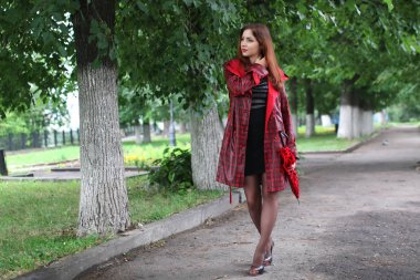 kadın bir yağmurluk ve şemsiye