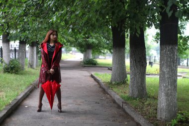 kadın bir yağmurluk ve şemsiye