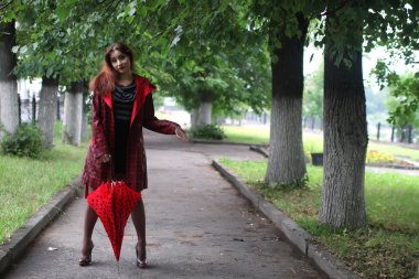 kadın bir yağmurluk ve şemsiye