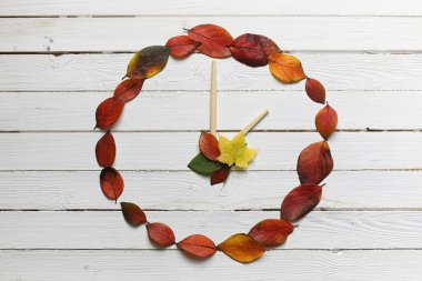 Beyaz ahşap zemin üzerinde saatler yaprakları