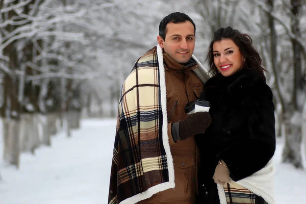 Vackra unga par i en snöig park — Stockfoto