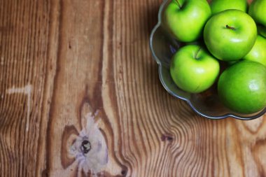 bir cam kase ahşap arka planda yeşil elma