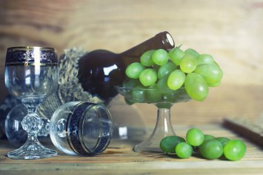 üzüm ve şarap şişesi kitap ile ahşap masa