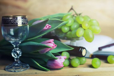 üzüm ve şarap şişesi kitap ile ahşap masa