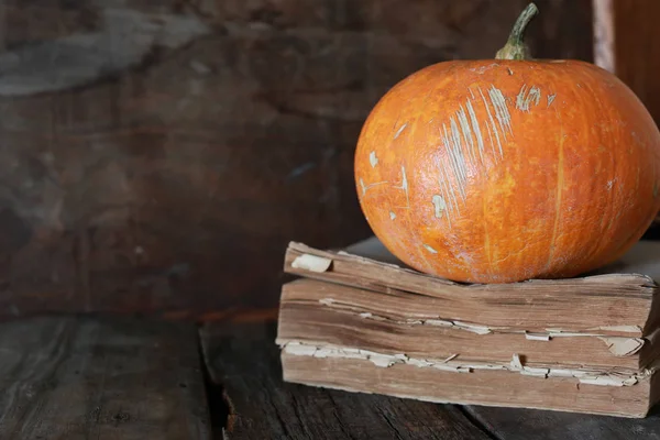 Citrouille sur vieux livre et fond en bois — Photo