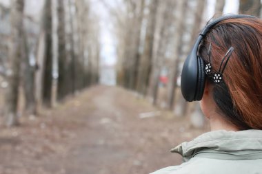 Sonbaharda parkta kulaklıklı bir kadın.