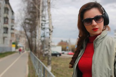 Sonbaharda parkta kulaklıklı bir kadın.