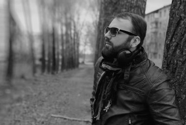 Kulaklıklı, parktaki sakallı adam.