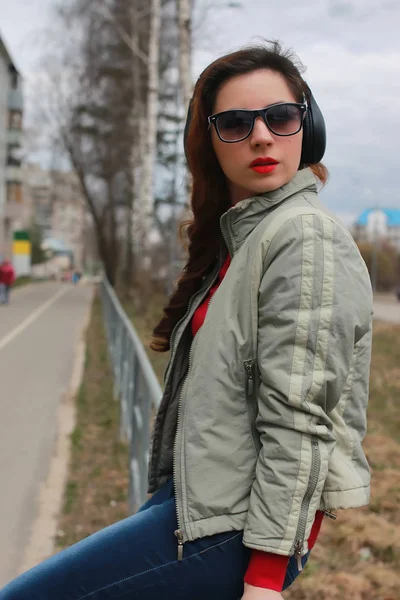 Sonbaharda parkta kulaklıklı bir kadın.