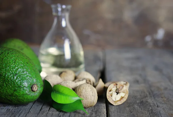 Авокадо и масло на деревянном фоне — стоковое фото