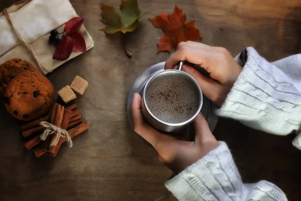Hands holding a mug of hot coffee on a table — Stock Photo, Image