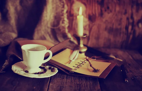 Retro objects feather and leaher book with candle light — Stock Photo, Image