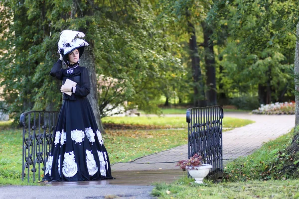 Renaissance-Frau mit Buch auf der Brücke im Park — Stockfoto