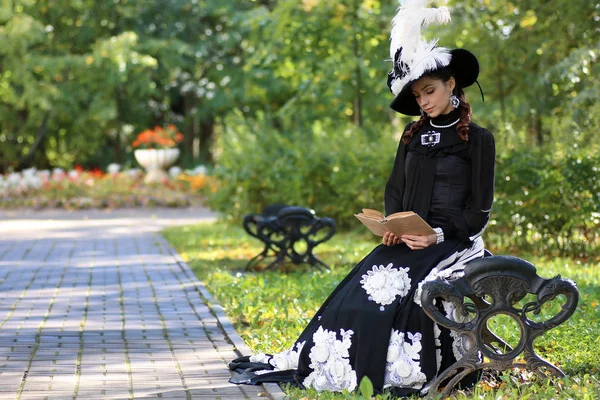 Girl in retro dress past century read letter on the bench — Stock Photo, Image